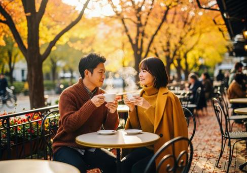 紅葉シーズンにテラスでお茶を飲むカップルの写真