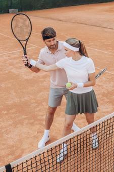 ネット前で構える女性とサポートする男性 男女,外国人,テニスの写真素材