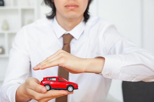 赤い車の模型を守る男性の手元 長髪,ボディパーツ,包むの写真素材