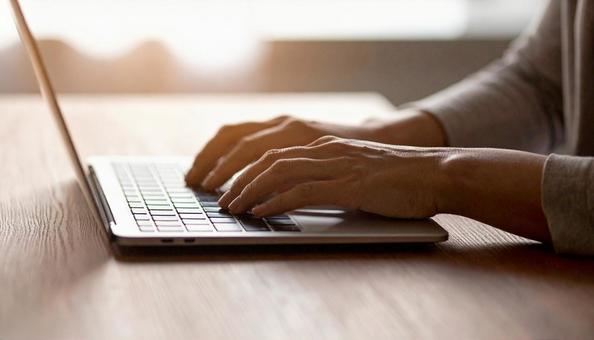 パソコンに両手で入力するデスクワーク パソコンに両手で入力するデスクワークの写真