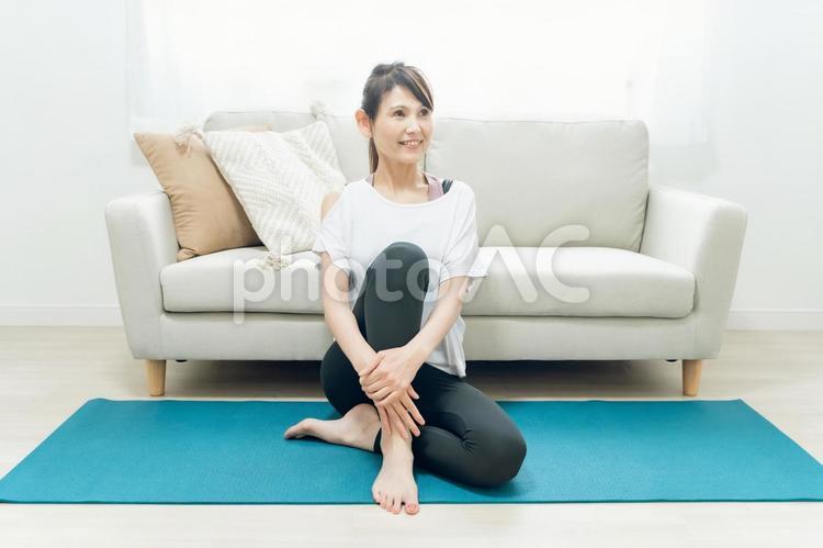 部屋でヨガをする中高年女性 オンラインヨガ,ストレッチ,インターネットの写真素材