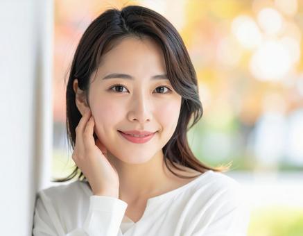 20代女性 顔に手を添えている女性 20代女性 顔に手を添えている女性の写真