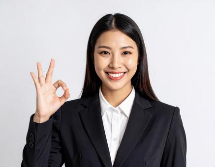 オーケーサインをするスーツ姿の女性の写真
