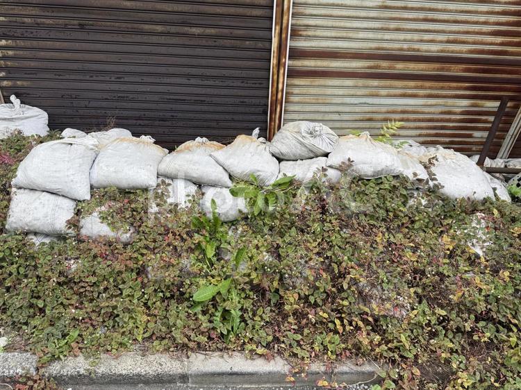 廃墟の前に積まれた土嚢 雑草,田舎,錆の写真素材