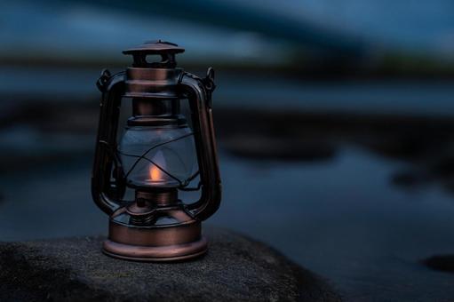 海の近くに置かれたアンティークランタン キャンプ,アウトドア,グランピングの写真素材