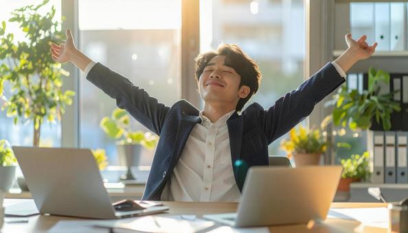 仕事が終わり達成感で背伸びをする社員 仕事が終わり達成感で背伸びをする社員の写真