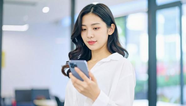 スマホを確認するビジネス女性 スマホを確認するビジネス女性の写真