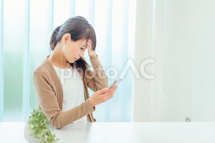 スマホを使う中高年の女性（アプリ・動画・困る） 主婦,悩む,スマートフォンの写真素材
