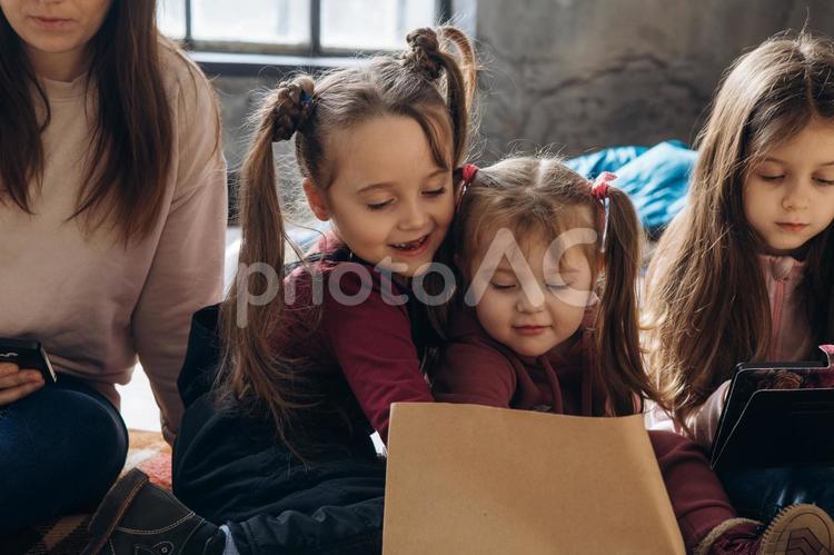 笑顔で紙袋の差し入れを見ている女の子 女性,女の子,人物の写真素材
