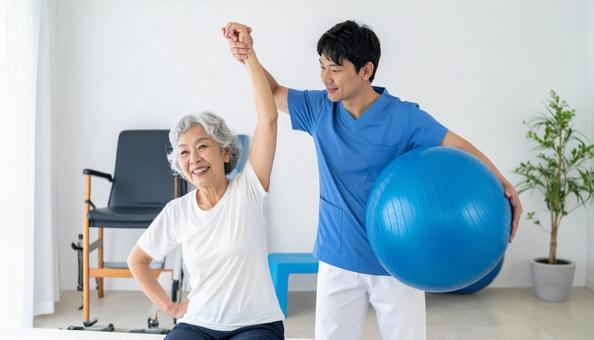 バランスボールでリハビリするシニア女性の写真