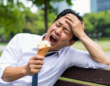 アイスを持ちながら暑さに苦しむ男性会社員 アイスを持ちながら暑さに苦しむ男性会社員の写真