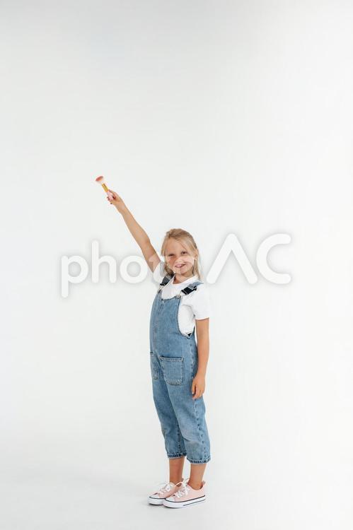 ブラシを上にあげて持つ笑顔の女の子 女の子,ブラシ,持つの写真素材
