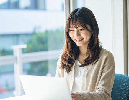 ノートパソコンを操作する若い女性 ノートパソコンを操作する若い女性の写真