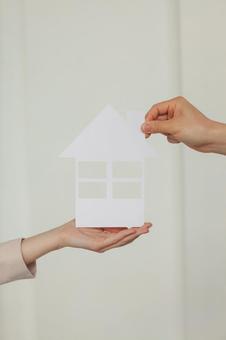 家の切り抜きを渡す手元 保険業,事務職,接客業の写真素材