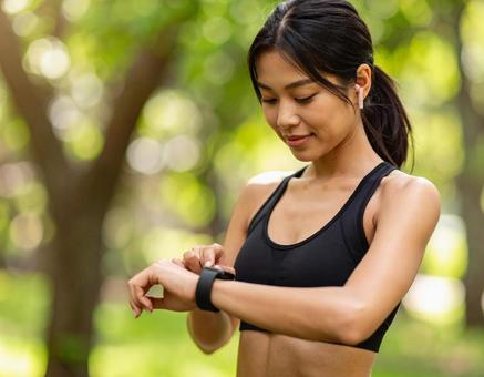 運動中にスマートウォッチを見る女性_01 運動中にスマートウォッチを見る女性_01の写真
