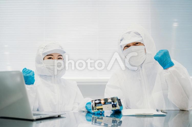 クリーンルームで精密機器を扱う男女 工場,クリーンルーム,製造業の写真素材