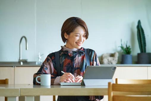 リビングルームで仕事をする女性 リビングルームで仕事をする女性 パソコン,pc,女性の写真素材