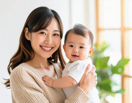 赤ちゃんを抱いて微笑んでいる若いお母さん 赤ちゃんを抱いて微笑んでいる若いお母さんの写真