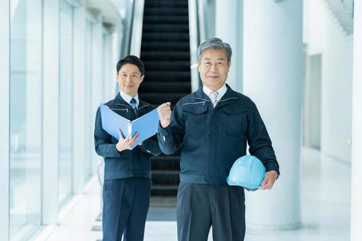 現場で打ち合わせする作業服のビジネスマン 現場で打ち合わせする作業服のビジネスマンの写真