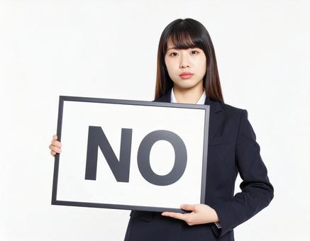 Noと書かれたボードを持つ女性社員 Noと書かれたボードを持つ女性社員の写真