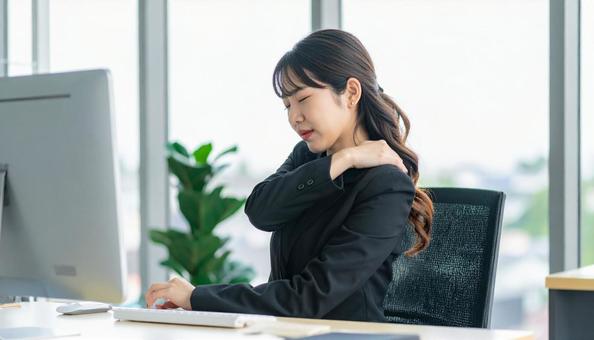 デスクワークで肩こりに悩むビジネスマン デスクワークで肩こりに悩むビジネスマンの写真