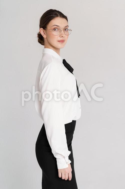 カメラ目線で微笑むメガネの女性 女性,立つ,振り向くの写真素材