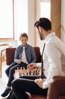ソファでチェスをするお父さんと男の子 ソファでチェスをするお父さんと男の子 チェス,親子,お父さんの写真素材
