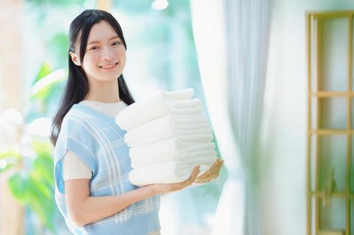 畳んだタオルを持つ黒髪の女性 女性,日本人,タオルの写真素材