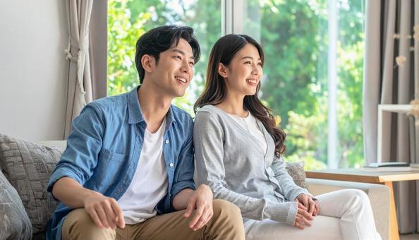 リビングでくつろぐ若いカップルの横顔 リビングでくつろぐ若いカップルの横顔の写真