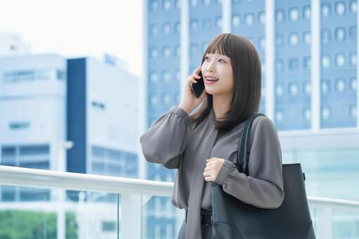 スマホで話す笑顔の女性・ビジネスウーマン 女性,スマホ,スマートフォンの写真素材