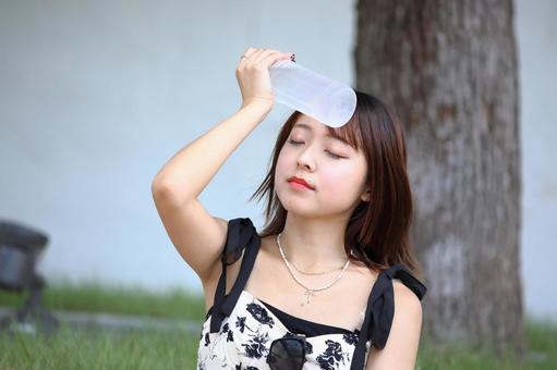 ペットボトルをおでこにあてる女性 ペットボトルをおでこにあてる女性 女性,若い,20代の写真素材