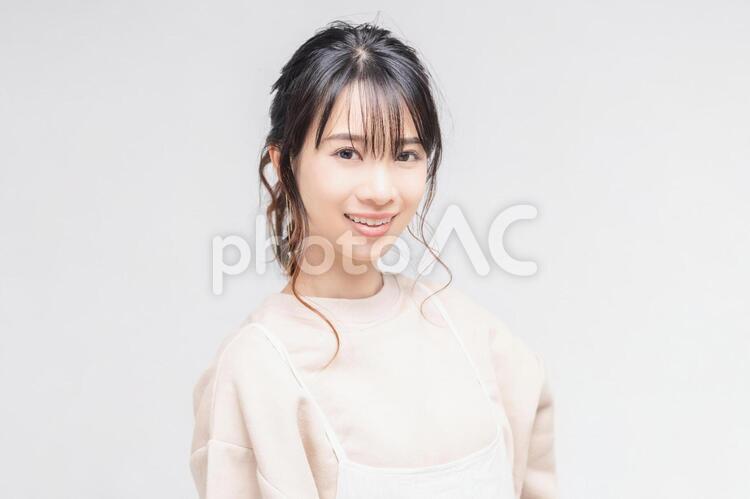 白い背景の前に立ってポーズをとる若い女性 女性,白背景,立つの写真素材
