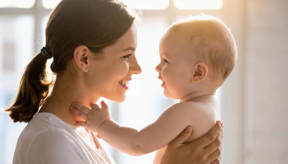 お母さんの顔を見る赤ちゃんの写真