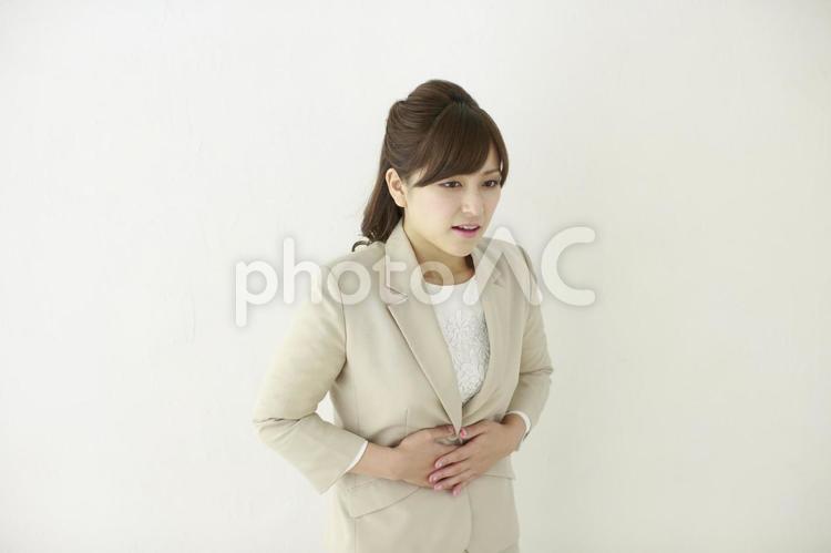 お腹を押さえるOL3 女性,ol,腹痛の写真素材