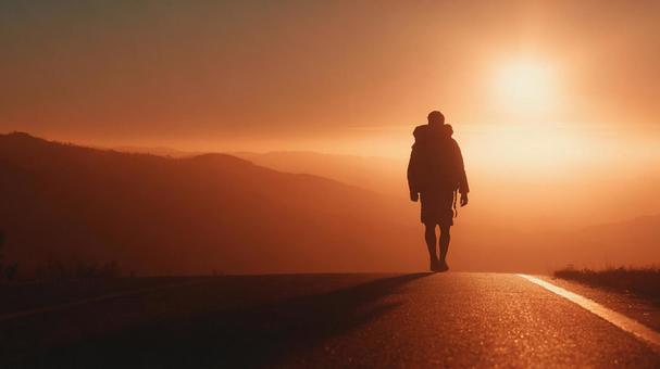 夕日に向かって歩く男性 夕日に向かって歩く男性の写真
