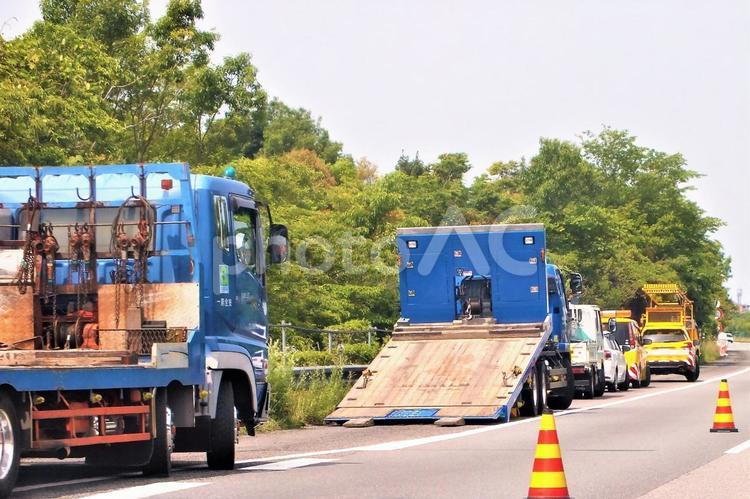 車両を運ぶトレーラーとトラック　工事現場 トレーラー,トラック,傾けるの写真素材