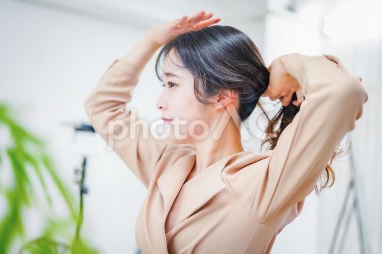 笑顔でメイクをする若い女性 スキンケア,美容,髪を結うの写真素材