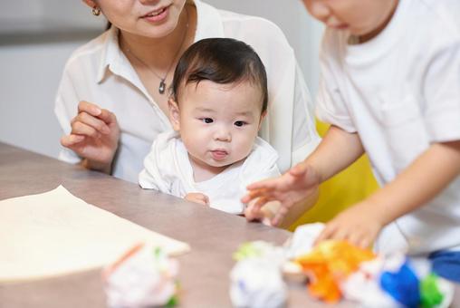 母親と一緒に遊ぶ子供達 母親と一緒に遊ぶ子供達 子ども,遊ぶ,折り紙の写真素材