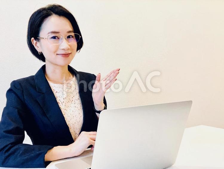 パソコンの前で案内をするスーツ姿の女性 女性,インタビュー,アドバイスの写真素材