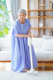 白い掃除機を持つ青いワンピース女性 女性,掃除,掃除機の写真素材