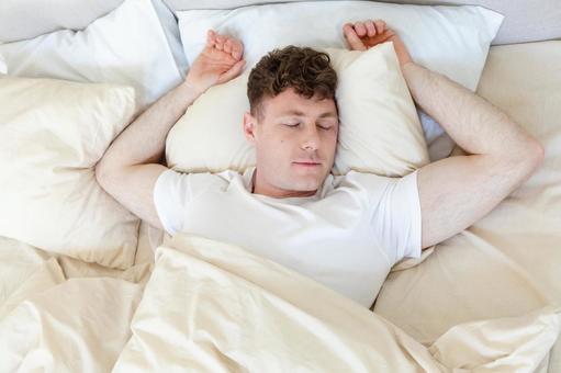 ベッドで仰向けで寝る男性 男性,外国人,欧米人の写真素材