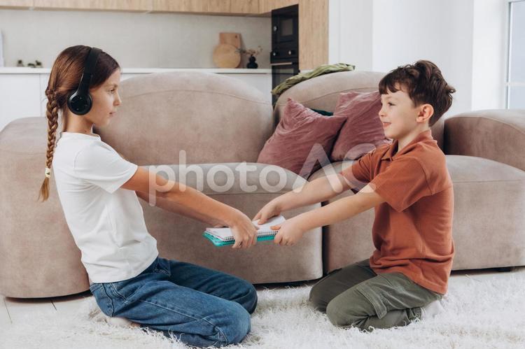 ノートの取り合いをする姉弟 姉弟,女の子,男の子の写真素材