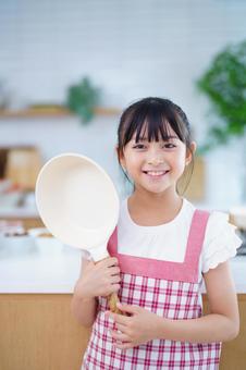 料理を始める前にポーズをとる女の子 女の子,フライパン,持つの写真素材