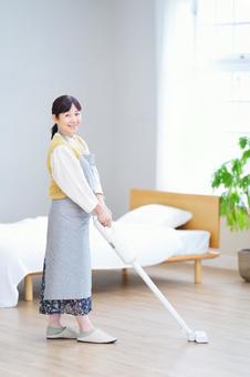 笑顔で掃除をする明るい雰囲気の女性 笑顔で掃除をする明るい雰囲気の女性の写真