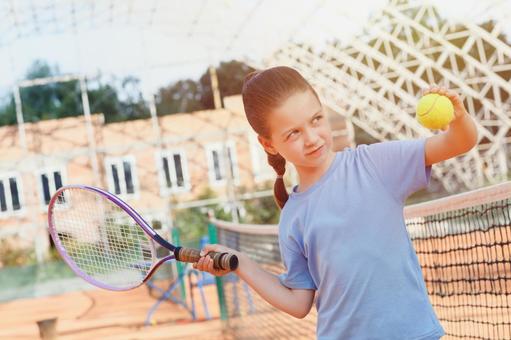 サーブの練習をする女の子　日差しの写真