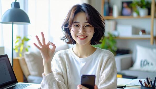 家計がうまくいきスマホ片手に微笑む女性 家計がうまくいきスマホ片手に微笑む女性の写真