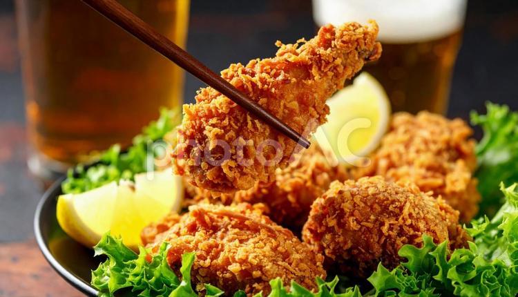 鶏の唐揚げを箸でとる ダイニングテーブル,鶏のから揚げ,おつまみの写真素材