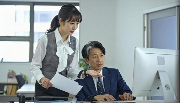 上司にデータを説明する女性社員 上司にデータを説明する女性社員の写真