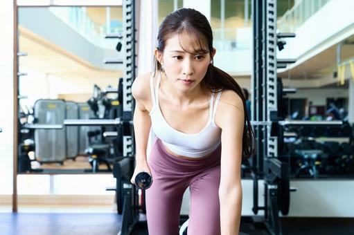 ダンベルで筋トレする女性 スポーツジム,ダンベル,トレーニングの写真素材