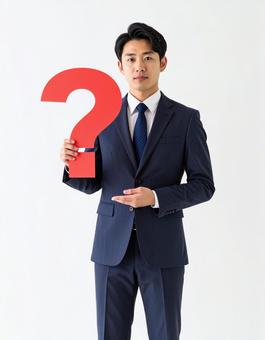 クエスチョンマークのオブジェを持つ男性 クエスチョンマークのオブジェを持つ男性の写真